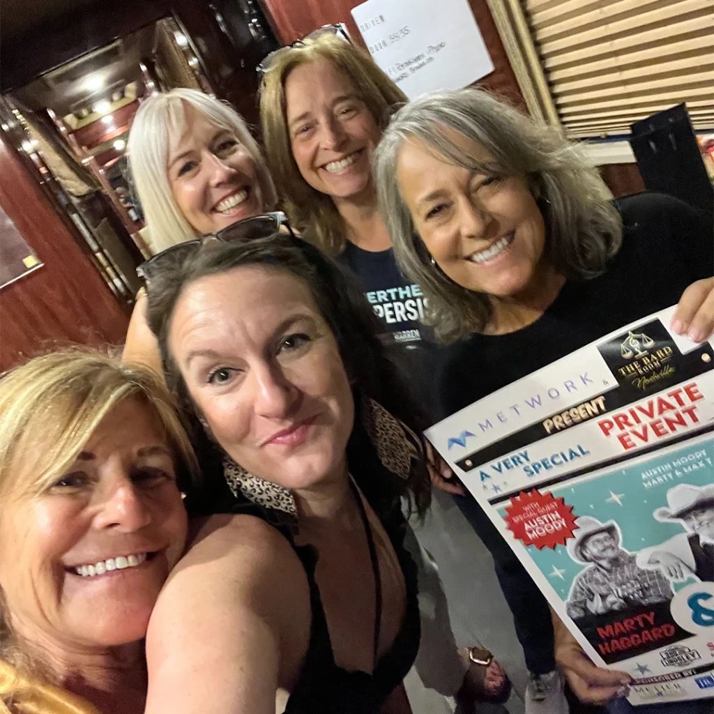 Metwork Major Account Manager Tara Lee (center) with event attendees on the band's tour bus. 